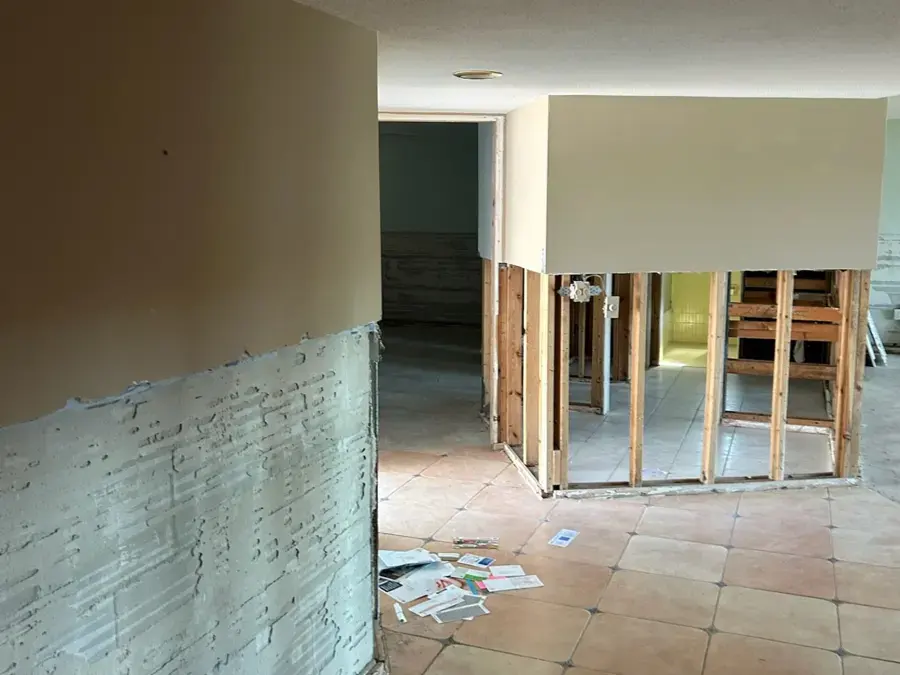 Flood-cut drywall and open framing above a tile floor during a Largo dry-out
