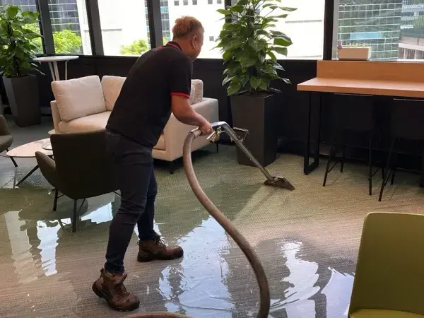 Extraction wand pulling water off office carpet in a flooded commercial space