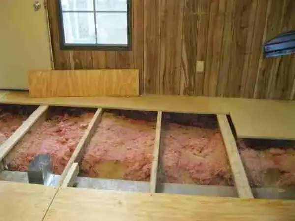 Manufactured home floor opened to wet insulation between the floor joists