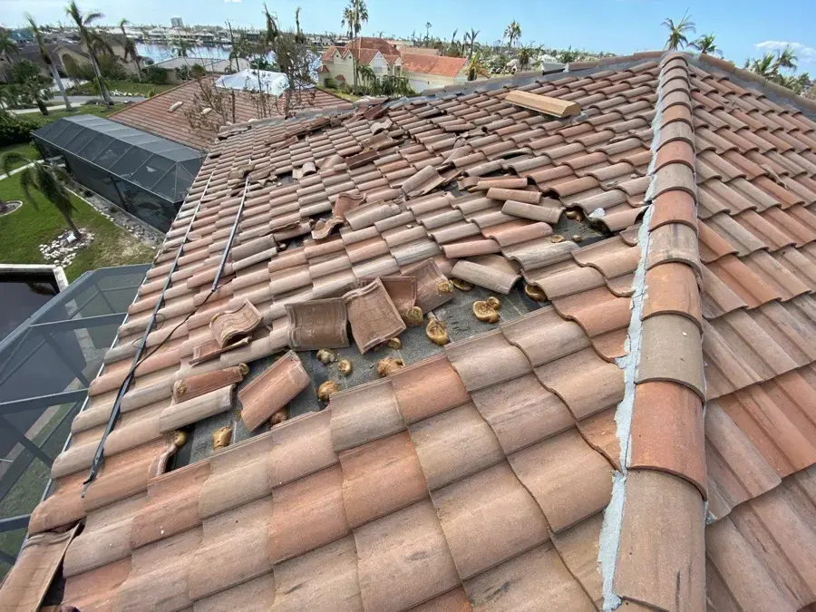Barrel tile roof with displaced tiles after tropical storm winds in Pinellas County