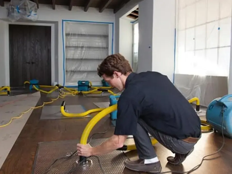 Extraction wand pulling water off a wet hardwood floor during a Largo dry-out